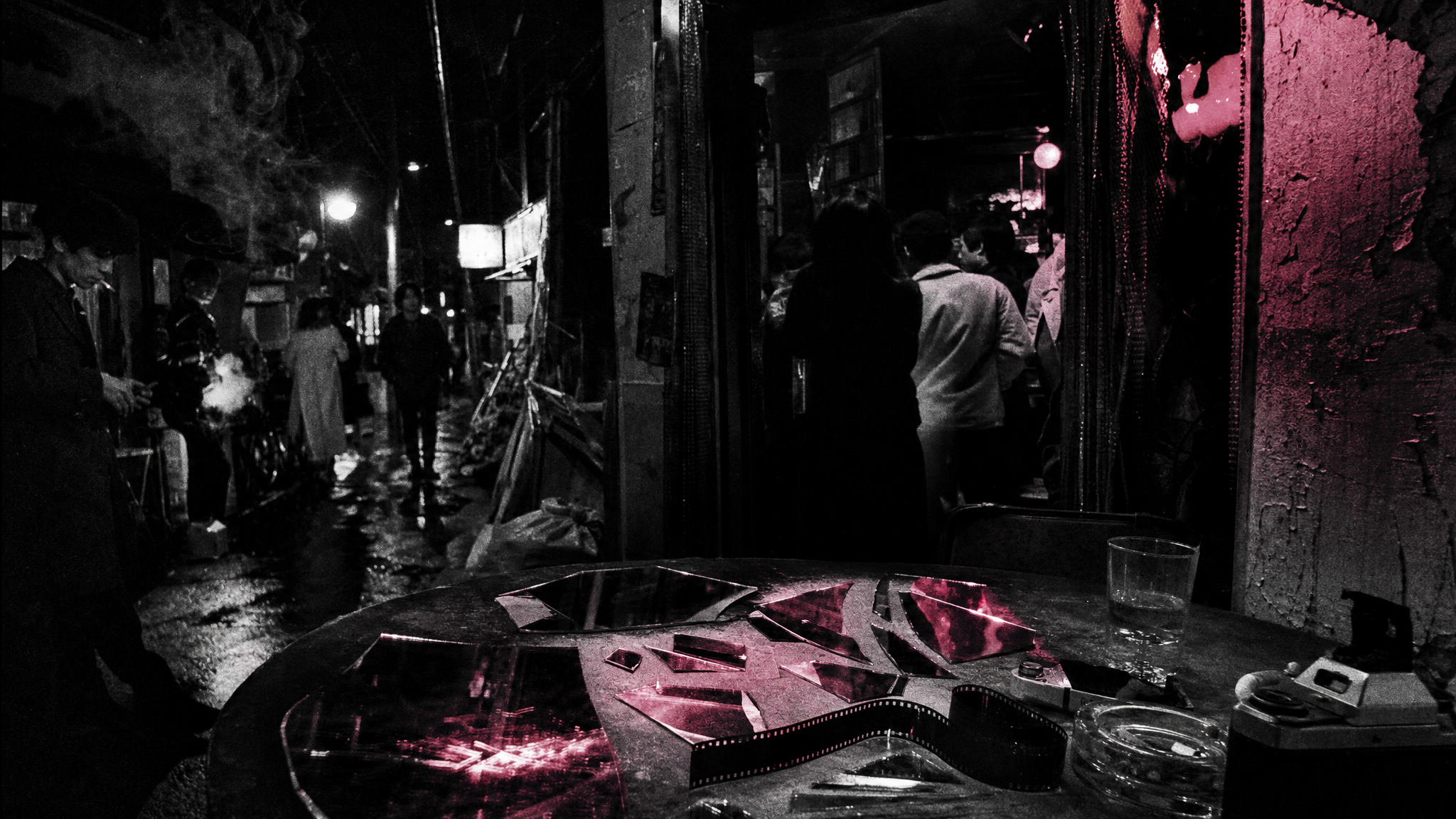 Callejón nocturno del Tokio underground con fragmentos de espejo y celuloide roto como rastro documental de Funeral Parade of Roses.